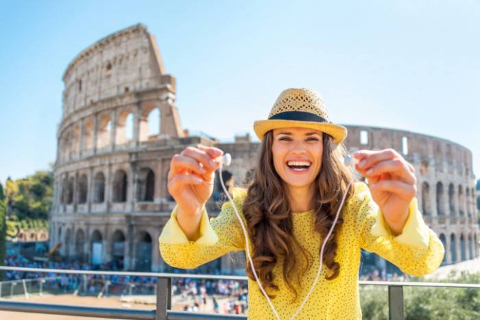 Woman giving headphones with audio guide near colosseum in rome