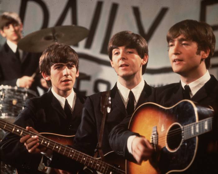 25th November 1963:  A group shot of the Beatles, Ringo Starr (in the background), George Harrison (1943 - 2001), Paul McCartney and John Lennon (1940 - 1980), pictured during a performance on Granada TV's Late Scene Extra television show filmed in Manchester, England on November 25, 1963.  (Photo by Fox Photos/Getty Images)