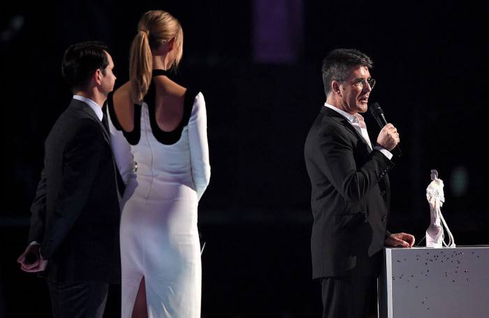 LONDON, ENGLAND - FEBRUARY 25:  Simon Cowell accepts the British Video of the Year Award for One Direction from Jimmy Carr and Karlie Kloss at the BRIT Awards 2015 at The O2 Arena on February 25, 2015 in London, England.  (Photo by Gareth Cattermole/Getty Images)