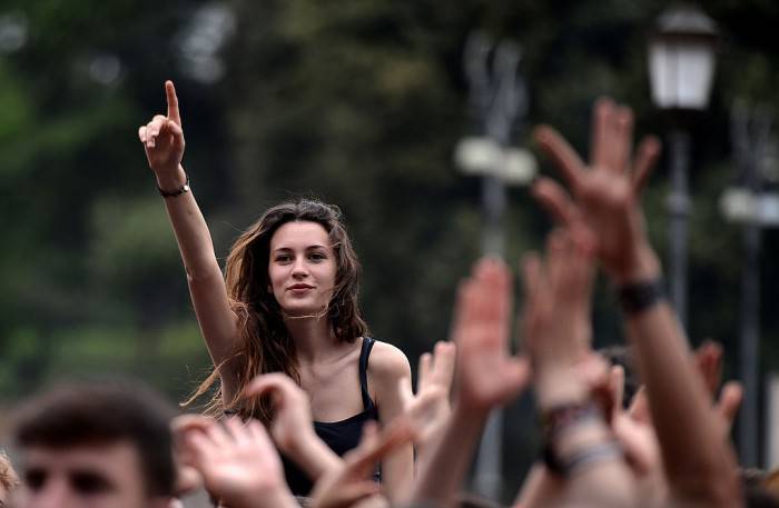 Youngsters attend the "workers' day concert" to celebrate Mayday in Rome's Piazza San Giovanni on May 1, 2013. AFP PHOTO / Filippo MONTEFORTE        (Photo credit should read FILIPPO MONTEFORTE/AFP/Getty Images)