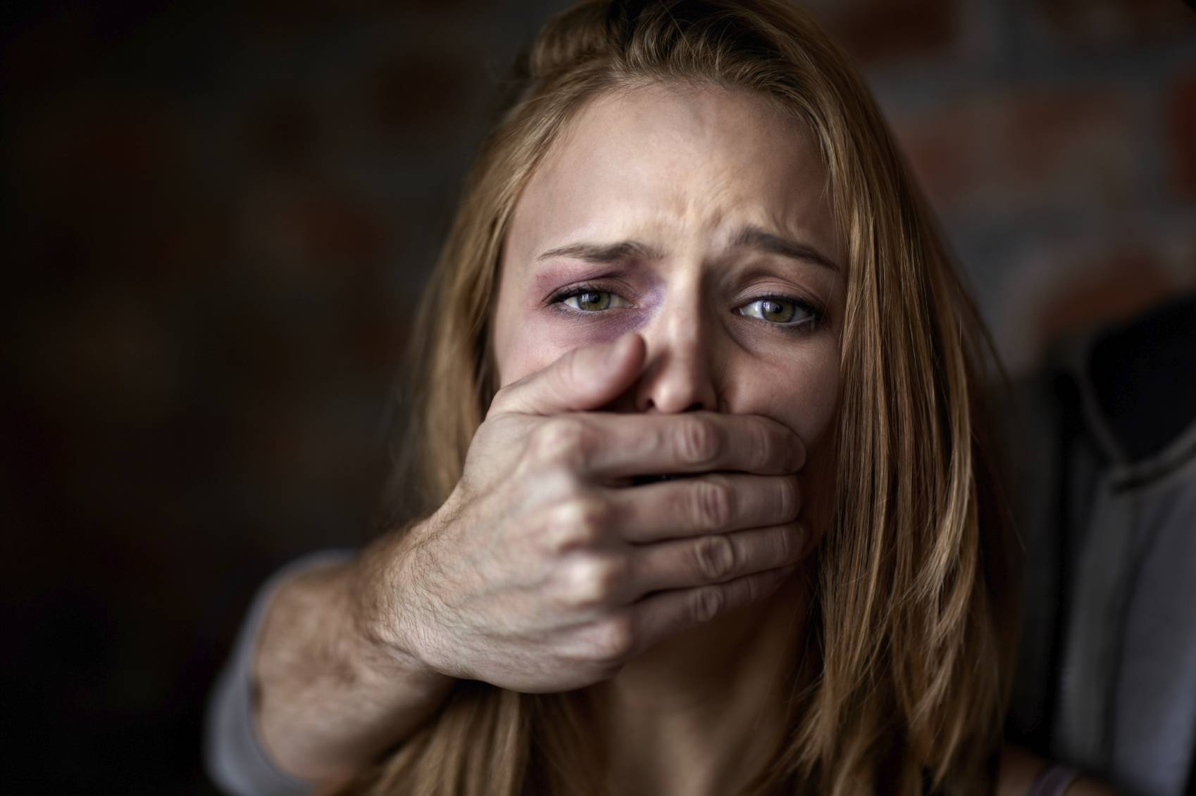 Abused young woman being silenced by her abuser