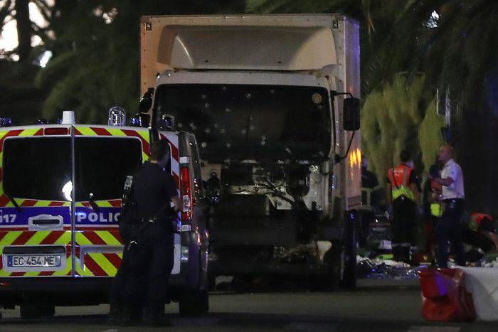 Police officers stand near a truck, with its windscreen riddled with bullets, that ploughed into a crowd leaving a fireworks display in the French Riviera town of Nice on July 14, 2016. At least 60 people were killed when a truck ploughed into a crowd watching a Bastille Day fireworks display in the southern French resort of Nice, prosecutors said early on July 15. Nice prosecutor Jean-Michel Pretre said the truck drove two kilometres (1.3 miles) through a large crowd that was watching the fireworks. / AFP / VALERY HACHE (Photo credit should read VALERY HACHE/AFP/Getty Images)