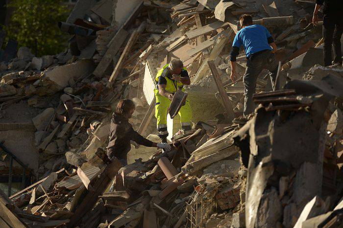 Resucers and residents clear debris in search for victims in damaged homes after a strong heathquake hit Amatrice on August 24, 2016. Central Italy was struck by a powerful, 6.2-magnitude earthquake in the early hours, which has killed at least three people and devastated dozens of mountain villages. Numerous buildings had collapsed in communities close to the epicenter of the quake near the town of Norcia in the region of Umbria, witnesses told Italian media, with an increase in the death toll highly likely. / AFP / FILIPPO MONTEFORTE        (Photo credit should read FILIPPO MONTEFORTE/AFP/Getty Images)
